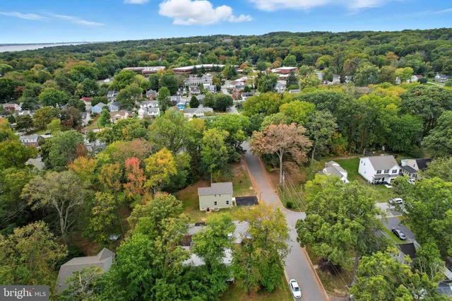 an aerial view of a residential houses with outdoor space and trees