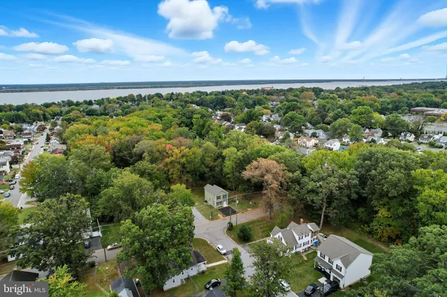 an aerial view of a houses with yard and mountain view in back