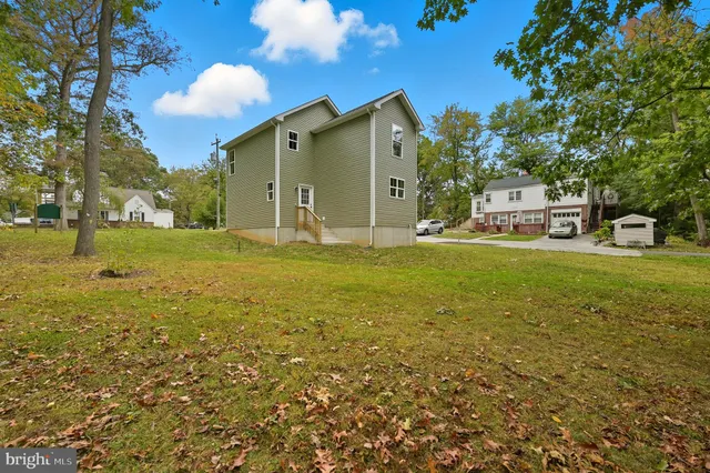 a view of a big house with a big yard and large trees