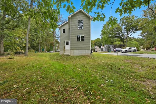 a view of a house with a big yard and large trees