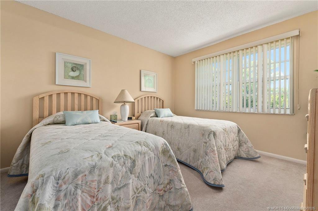 1913 Southwest Palm City Road, Unit 7F Stuart, FL 34994 - Photo 15 of 28 a bedroom with two bed and a large window