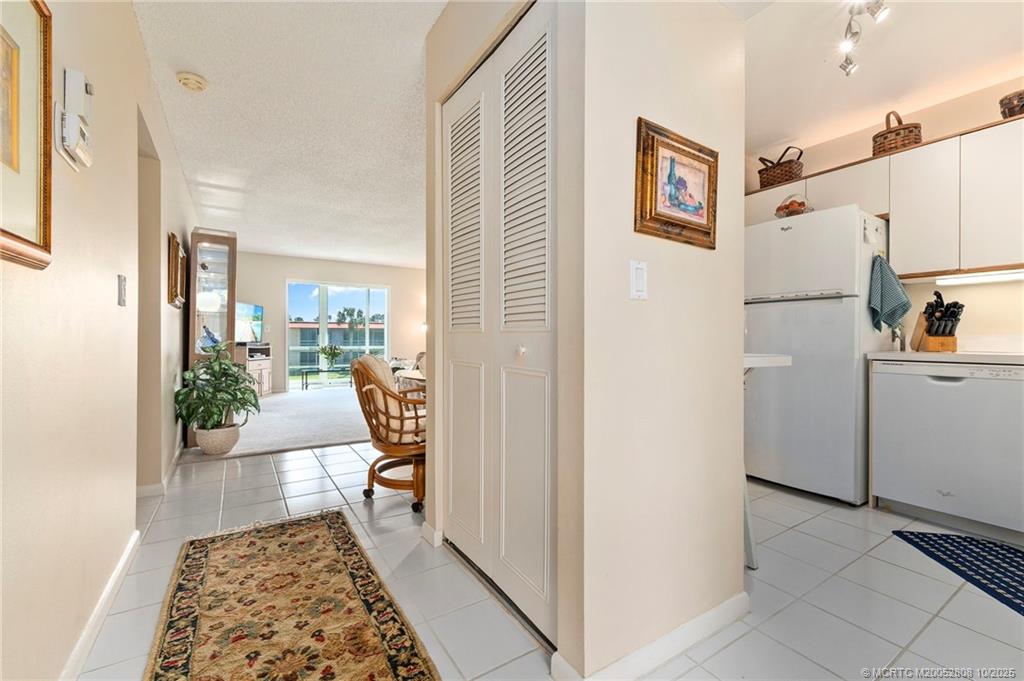 1913 Southwest Palm City Road, Unit 7F Stuart, FL 34994 - Photo 4 of 28 a hallway with a dining table and a stove top oven