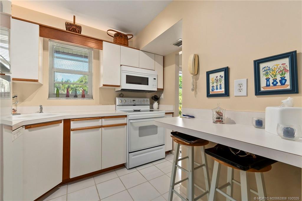 1913 Southwest Palm City Road, Unit 7F Stuart, FL 34994 - Photo 6 of 28 a kitchen with stainless steel appliances a stove sink and microwave
