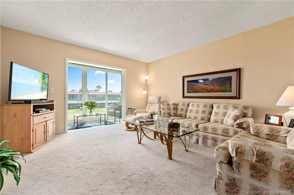 1913 Southwest Palm City Road, Unit 7F Stuart, FL 34994 - Photo 9 of 28 a living room with furniture and a flat screen tv