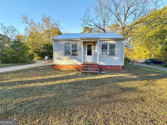a view of a house with backyard and sitting area