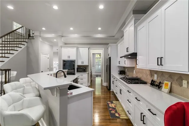 a kitchen with stainless steel appliances kitchen island granite countertop a sink and cabinets