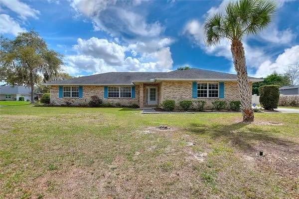 a view of house with a big yard and potted plants