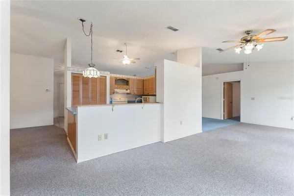 a view of a kitchen with a refrigerator ceiling fan and wooden floor