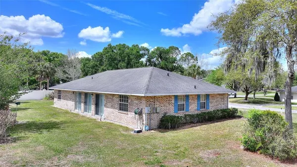 a aerial view of a house with a yard table and chairs