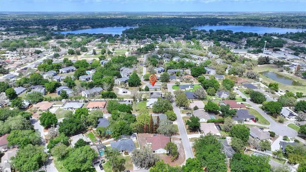 an aerial view of residential houses with outdoor space and trees