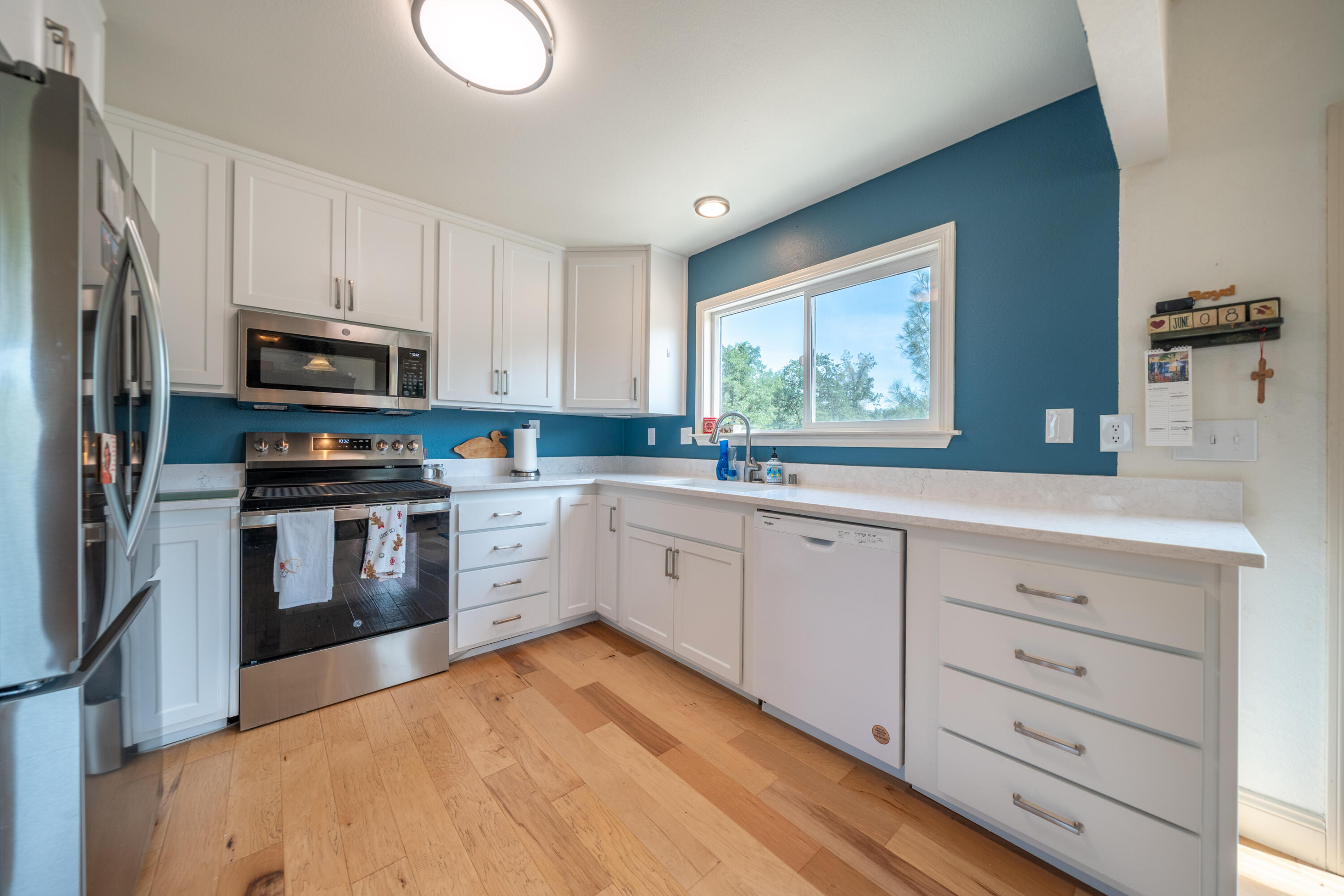 15842 Macleod Drive Redding, CA 96001 - Photo 9 of 36 a kitchen with granite countertop white cabinets and stainless steel appliances
