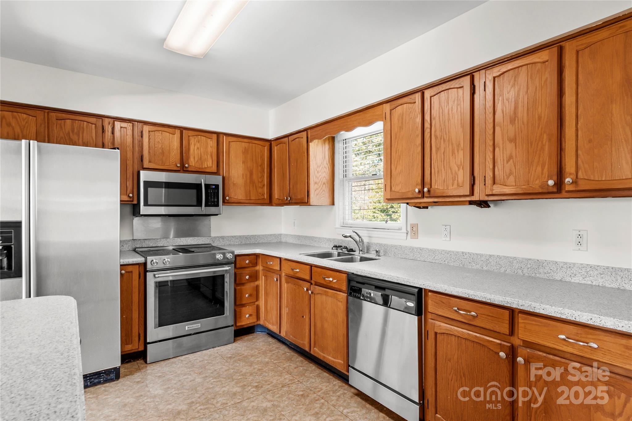1180 Faulkenberry Road King, NC 27021 - Photo 15 of 40 a kitchen with stainless steel appliances granite countertop a sink dishwasher stove and refrigerator with wooden cabinets