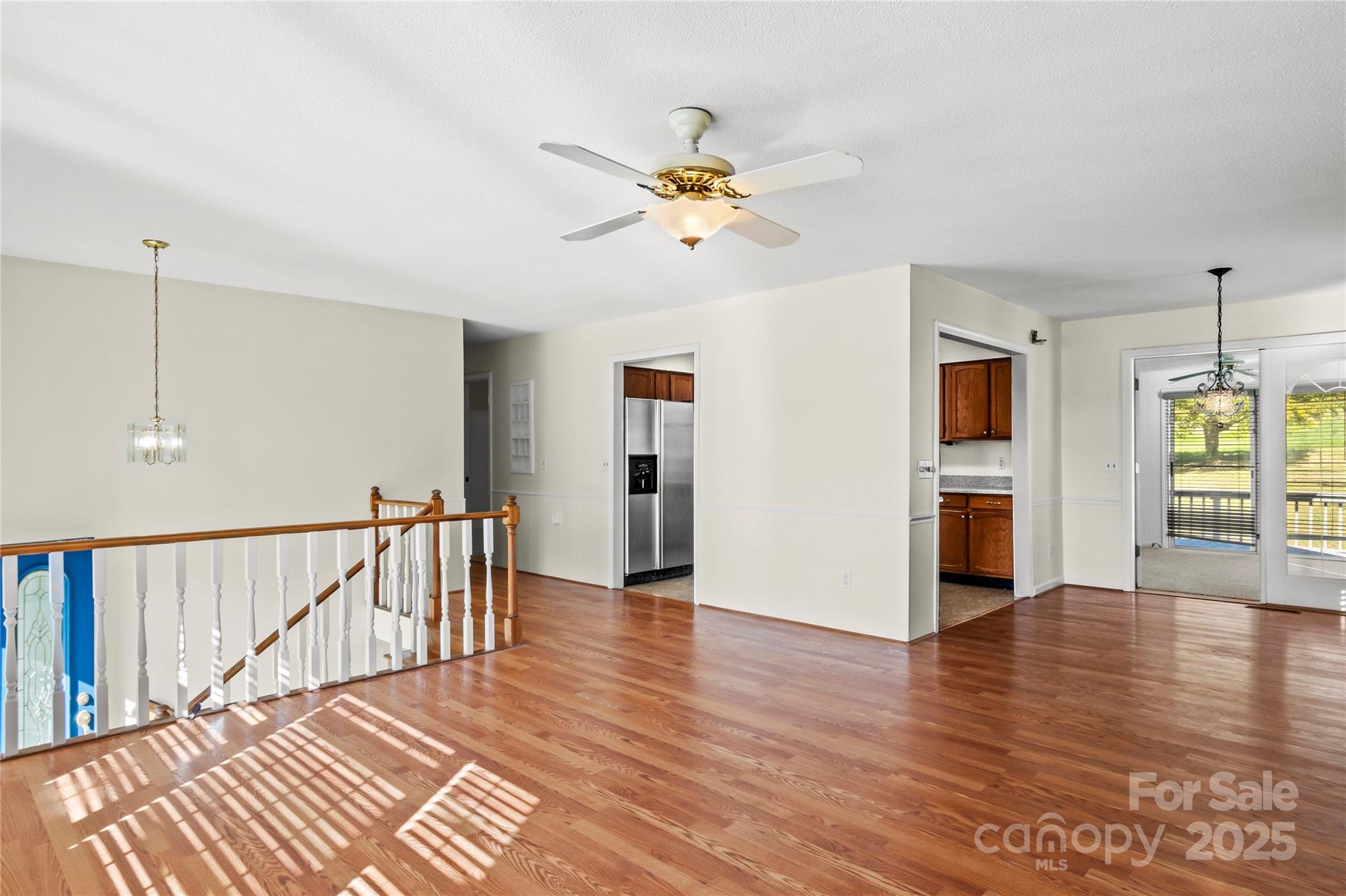 1180 Faulkenberry Road King, NC 27021 - Photo 10 of 40 a view of a livingroom with wooden floor a ceiling fan and windows
