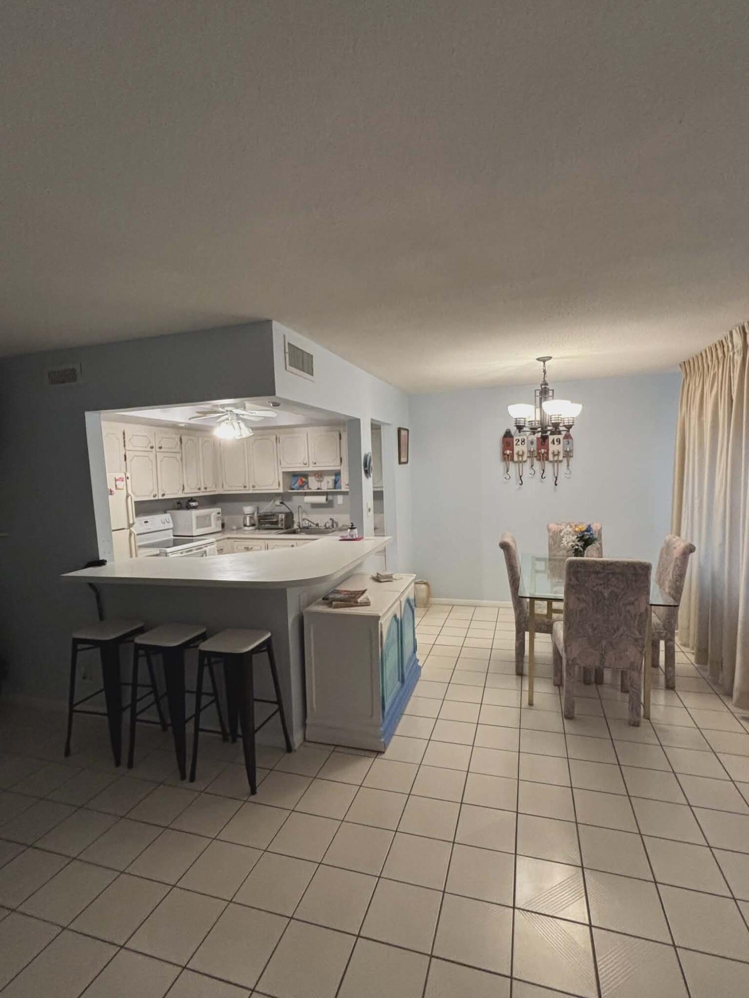 5550 North Ocean Boulevard, Unit 106 Ocean Ridge, FL 33435 - Photo 3 of 15 a kitchen with a table and chairs