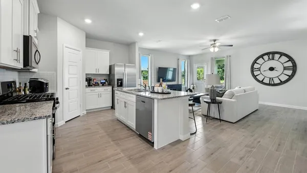 a kitchen with stainless steel appliances kitchen island granite countertop a refrigerator and a stove top oven