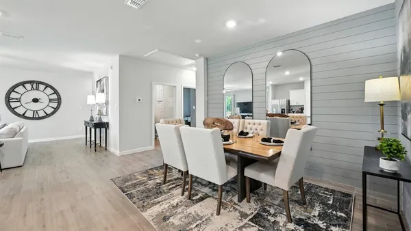 a living room with stainless steel appliances granite countertop furniture a fireplace a flat screen tv and a window