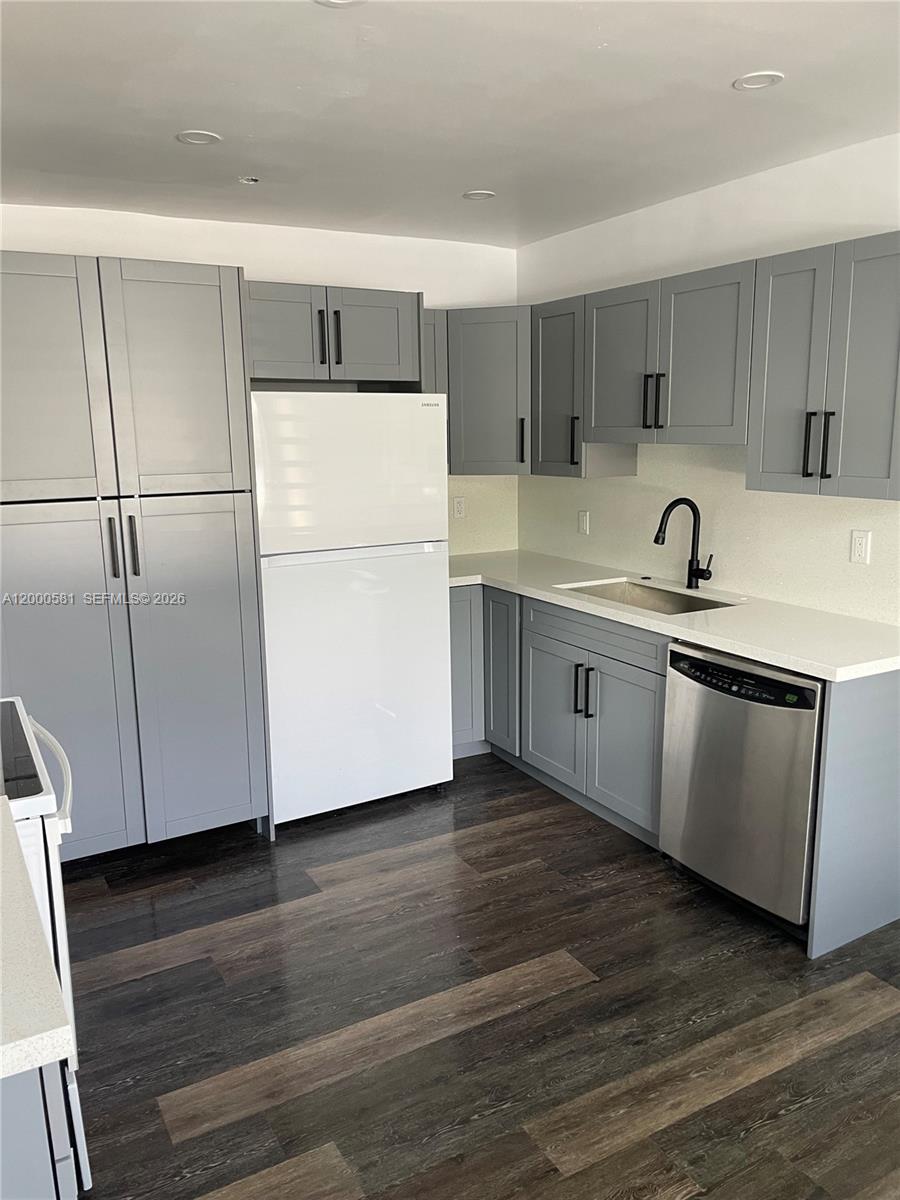 2350 Southwest 26th Lane Miami, FL 33133 - Photo 3 of 12 a kitchen with kitchen island a sink and wooden floors