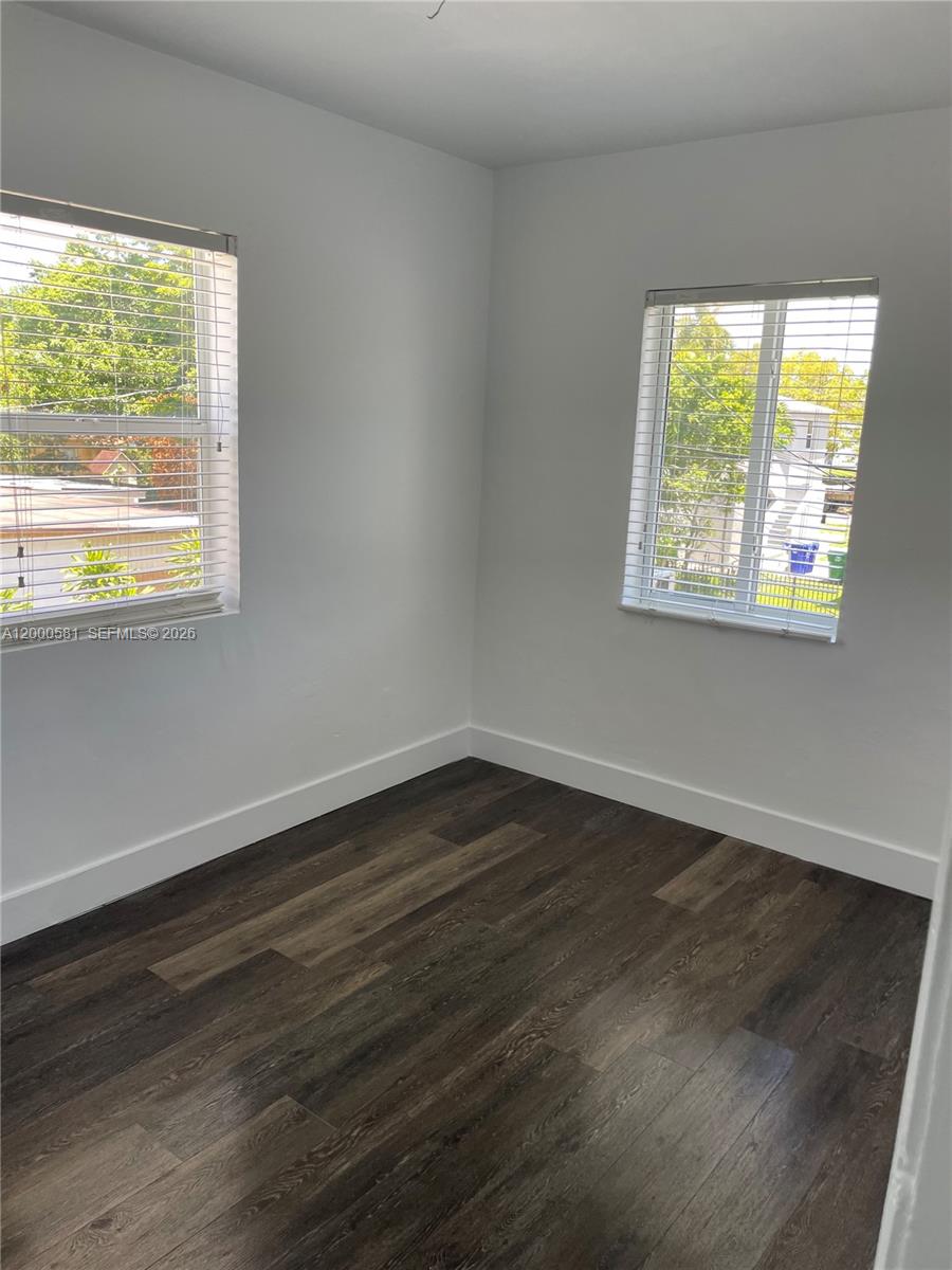 2350 Southwest 26th Lane Miami, FL 33133 - Photo 9 of 12 a view of an empty room with wooden floor and a window