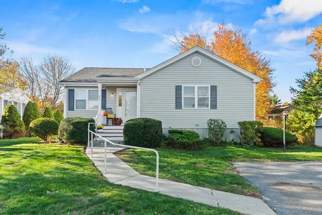 a view of a house with a yard and chairs