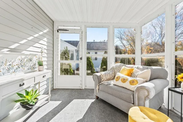 a living room with furniture potted plant and a large window
