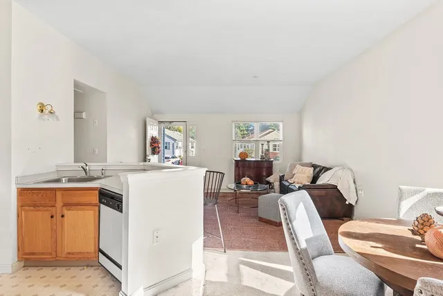 a living room with furniture a dining table and with natural light