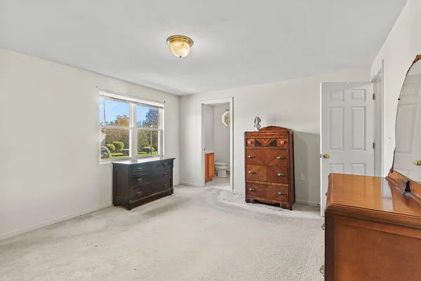 a view of a bedroom with furniture and window