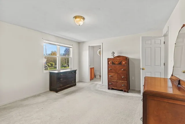 a view of a bedroom with furniture and window