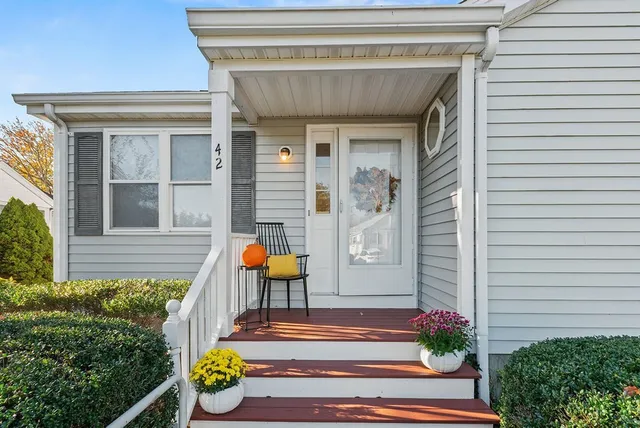 a front view of a house with outdoor seating and garage