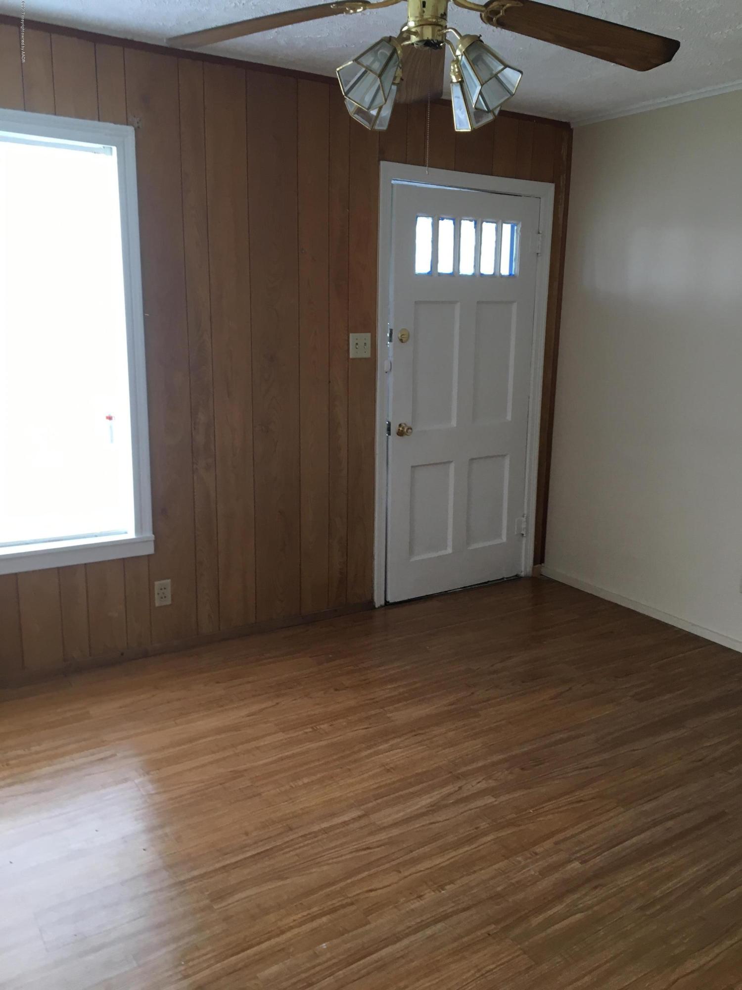 4128 South Polk Street Amarillo, TX 79110 - Photo 5 of 10 an empty room with wooden floor cabinet and windows