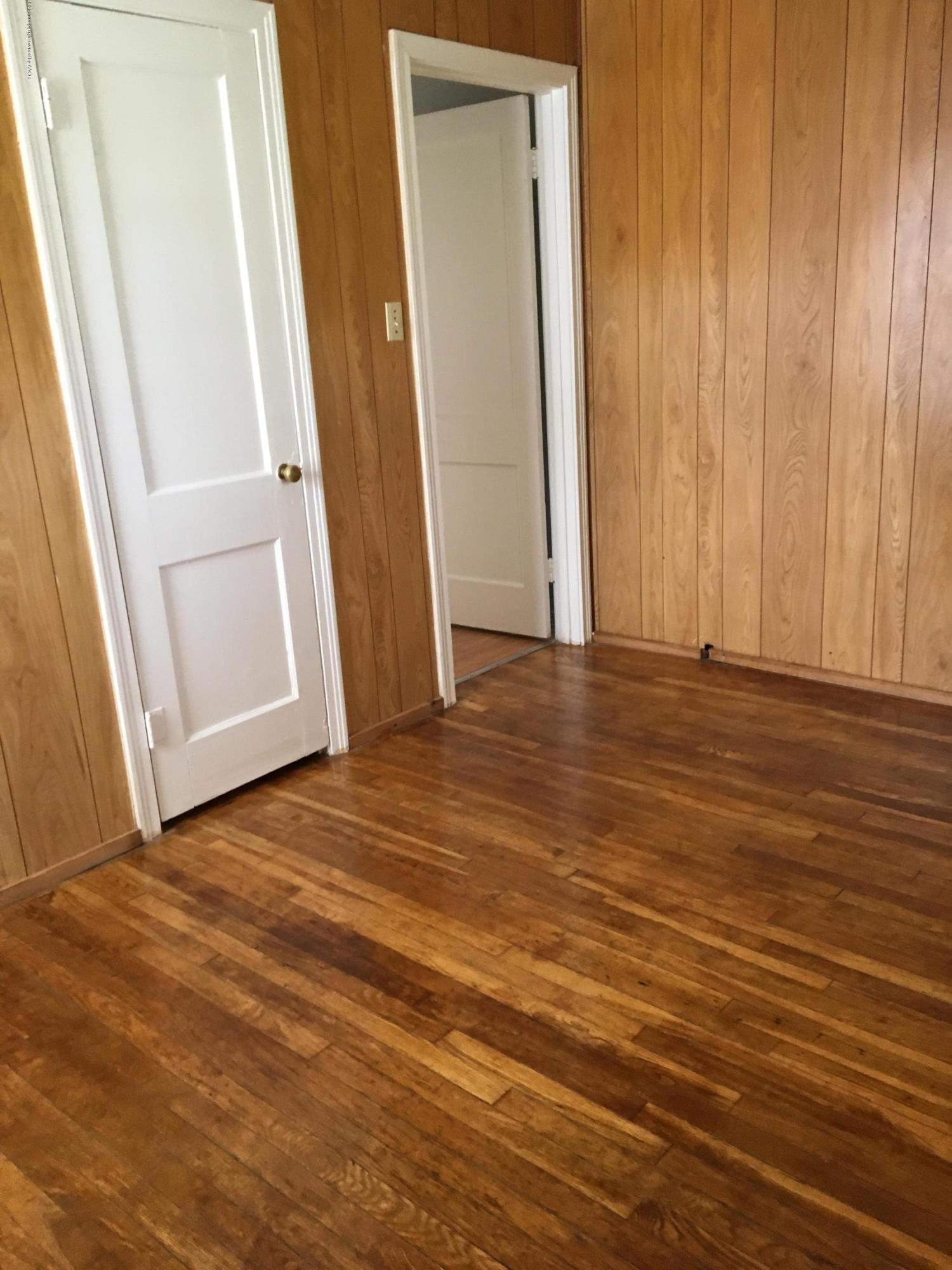 4128 South Polk Street Amarillo, TX 79110 - Photo 8 of 10 an empty room with wooden floor and entrance