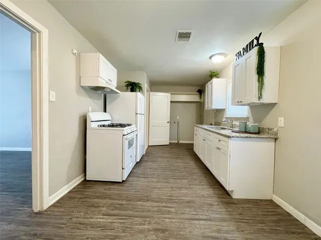 a kitchen with white cabinets and white appliances