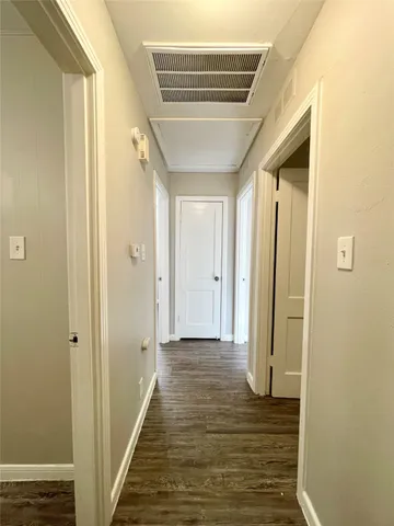 a view of a hallway with wooden floor and staircase