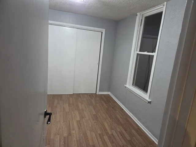 an empty room with wooden floor and entrance