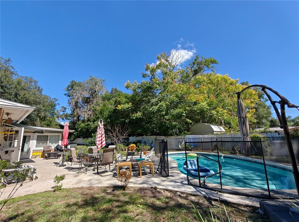 2305 Northwest 48th Terrace Gainesville, FL 32606 - Photo 14 of 20 a view of backyard with a table and chairs and potted plants