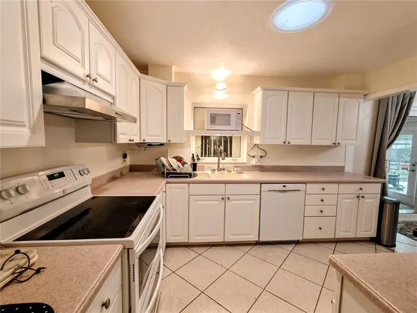a kitchen with a sink a stove a microwave and wooden cabinets