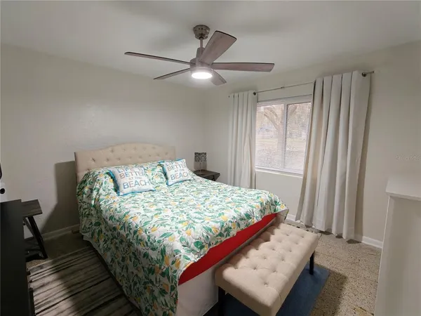 a bed sitting in a bedroom next to a window