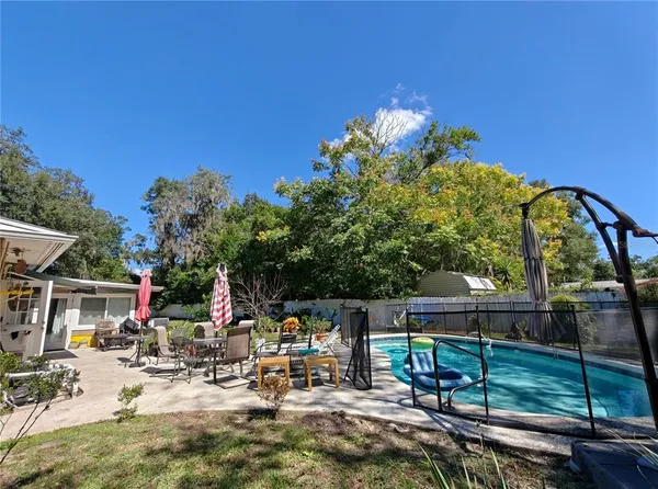a view of backyard with a table and chairs and potted plants