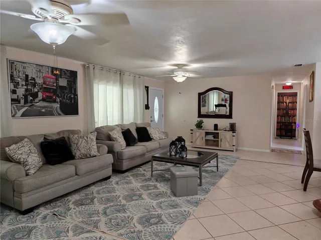a living room with furniture a book shelf and a window