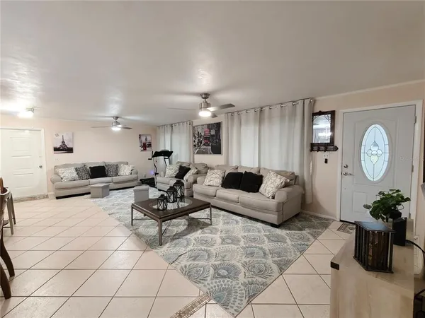 a living room with furniture a clock and a potted plant