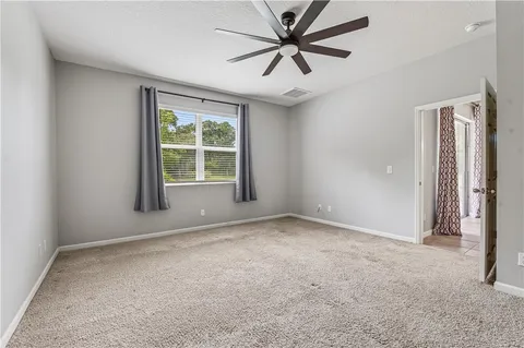 an empty room with fan and entrance