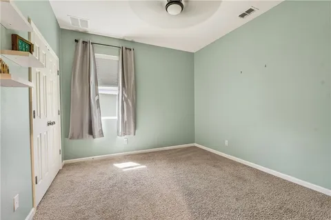 an empty room with a window and a ceiling fan