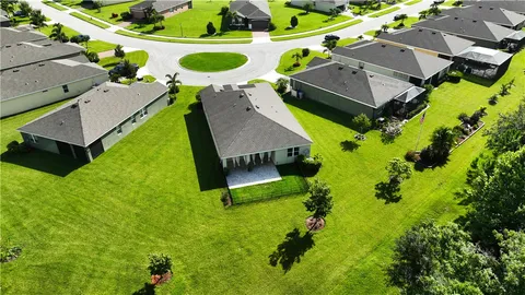 an aerial view of a house with a yard and lake view