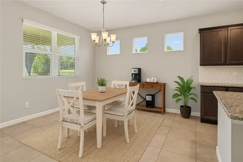 a dining room with furniture potted plants and wooden floor