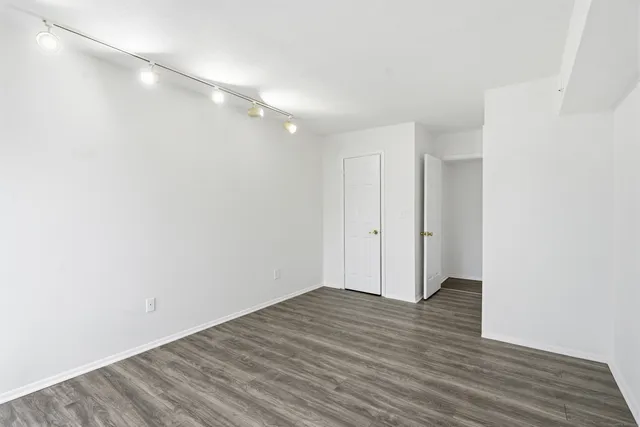 a view of an empty room with wooden floor