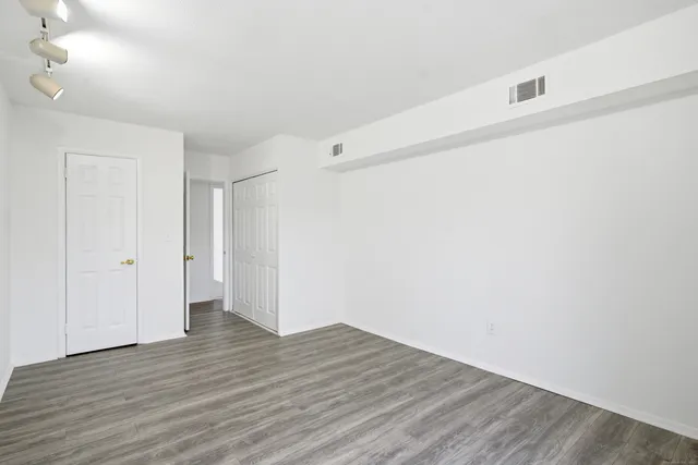 a view of an empty room with wooden floor