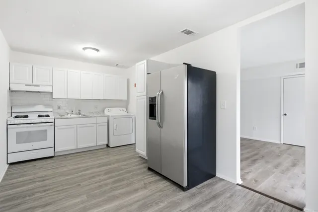 a kitchen with a refrigerator sink and cabinets