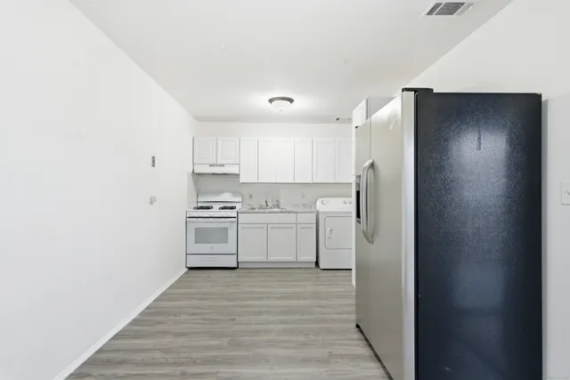 a kitchen with a refrigerator sink and cabinets