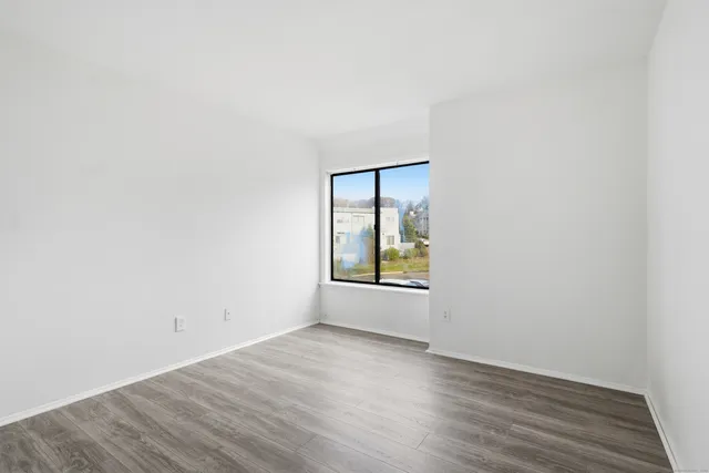 an empty room with wooden floor and a window