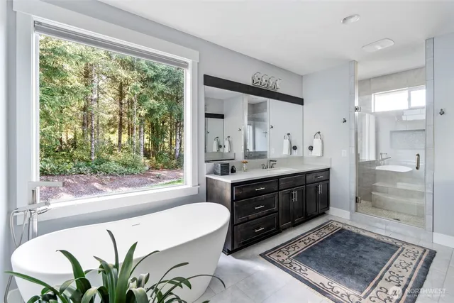 a spacious bathroom with a double vanity sink a large mirror and a bathtub