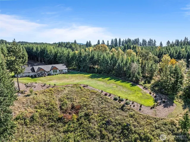 a front view of a house with a yard covered with trees